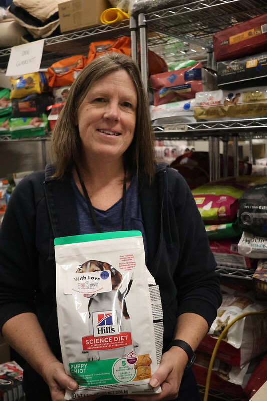 OHS pet food bank volunteer holding a bag of pet food