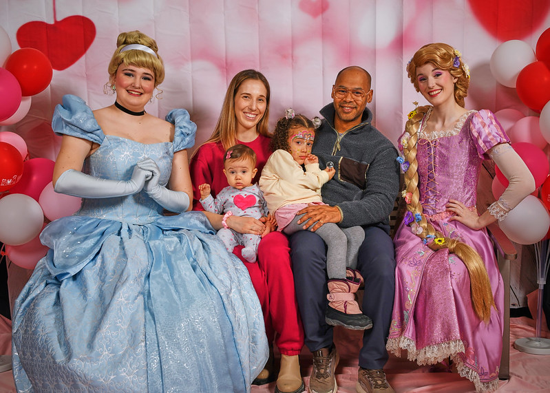 Family posing with princesses for Valentine's photo shoot. 