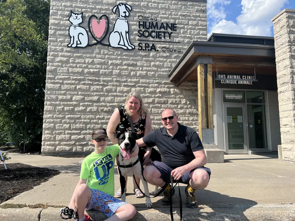 A family and their dog outside the animal shelter.