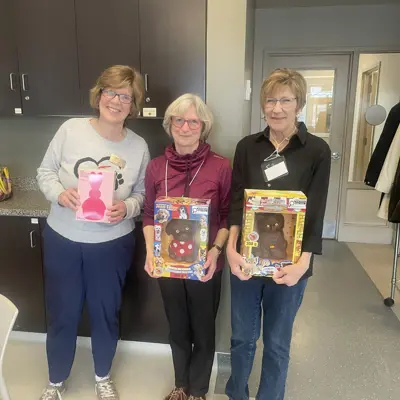 Enjoying social time at a monthly Auxiliary meeting: Our guest speaker Jean Nelson (left), Chair OHS Board of Directors, presents our raffle winners with their prizes.