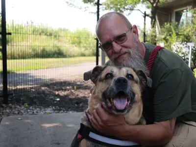 Bearded man cuddling his dog